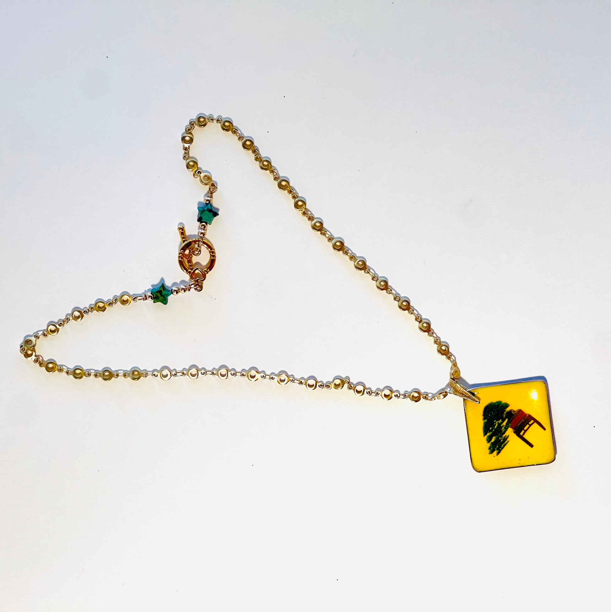 Juniper bonsai cascading below tabletop, paired with delicate gold vermeil chain