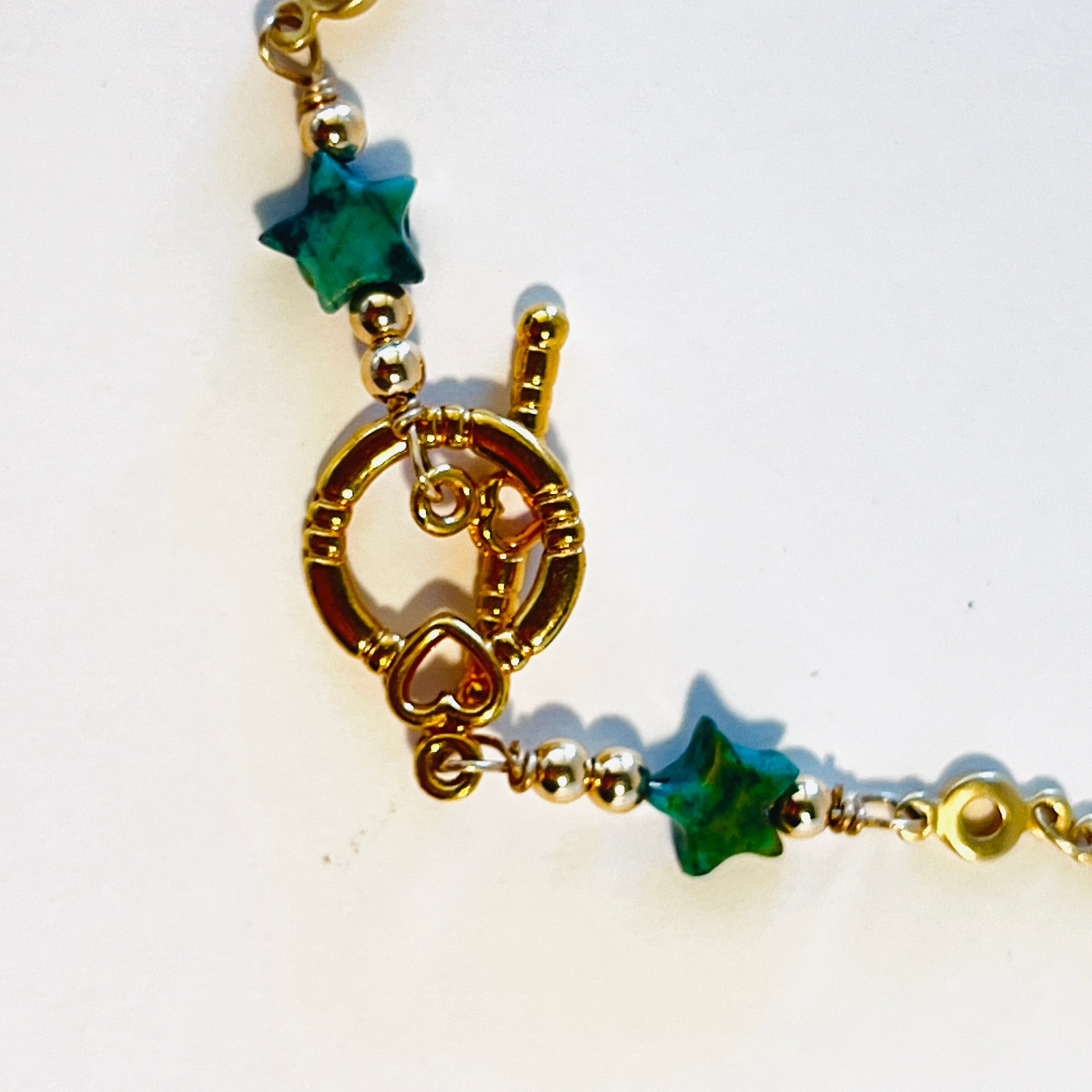 Juniper bonsai cascading below tabletop, paired with delicate gold vermeil chain