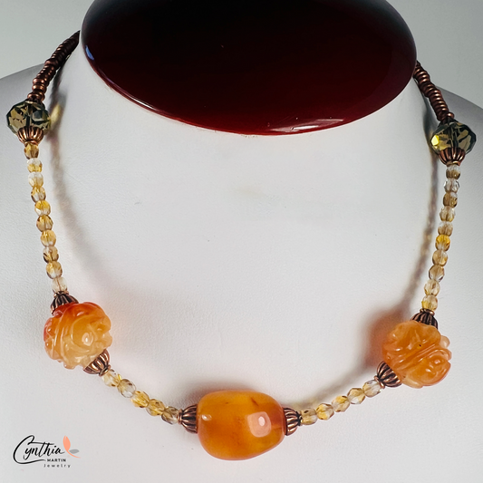 Striking necklace featuring rich Baltic amber, etched milky orange Indonesian stones, green faceted beads, and copper accents, 15 inches with a 2-inch extender.