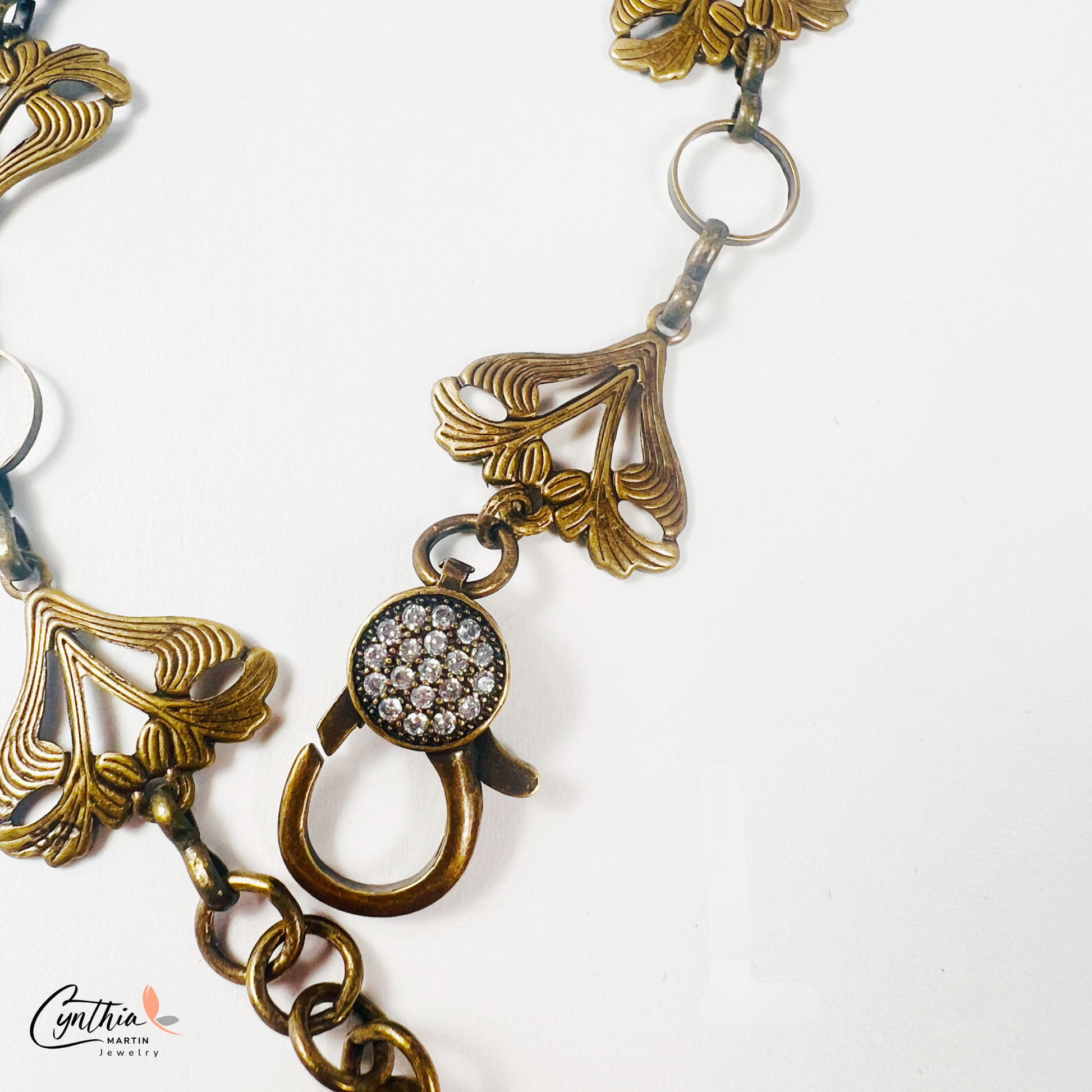 Art Nouveau-inspired jewelry set featuring delicate sun-kissed garden flowers, a bronze bonsai tree charm, and a sparkling pavé lobster clasp.