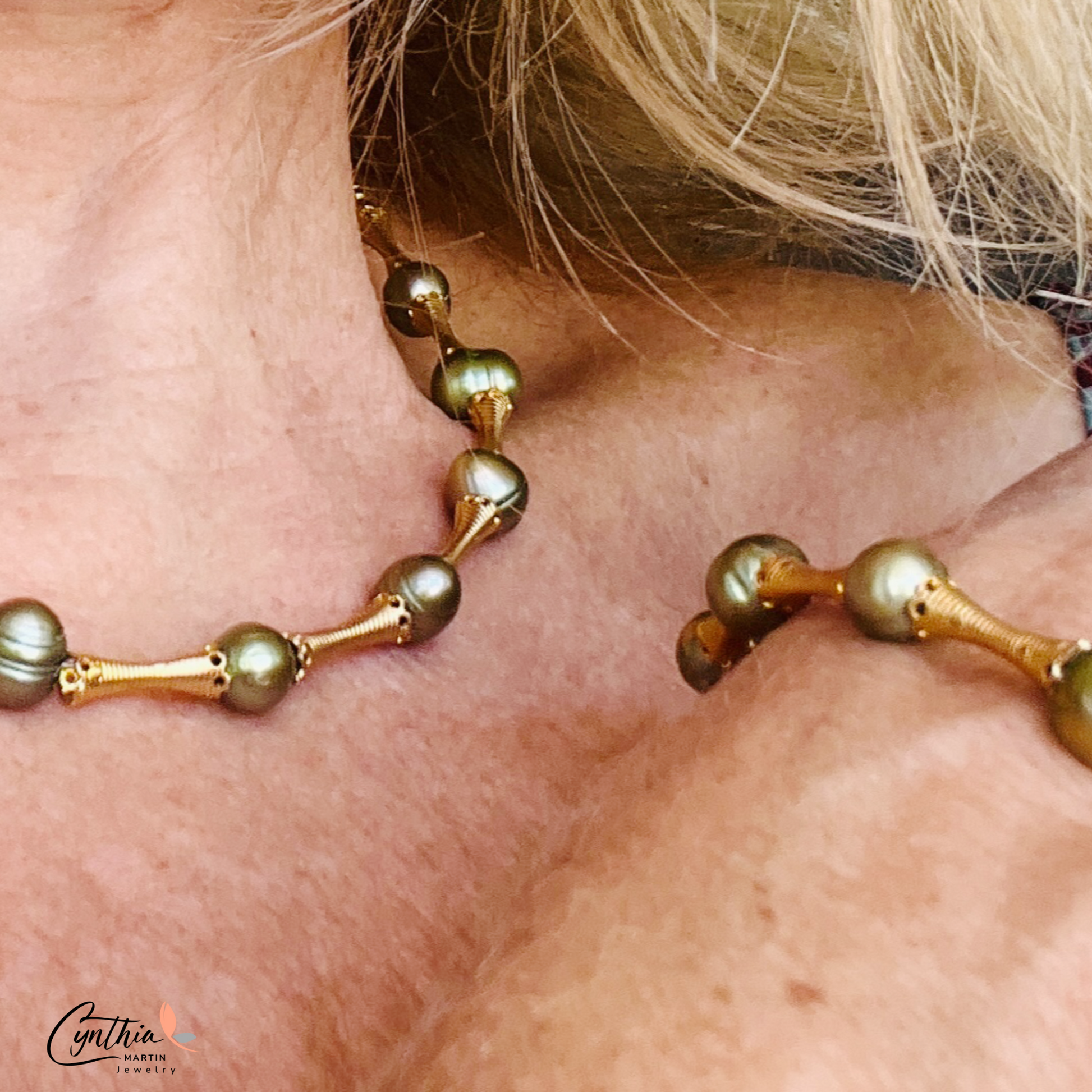 Stylish bracelet with iridescent green pearls and gold tube spacers, perfect for casual or corporate attire.