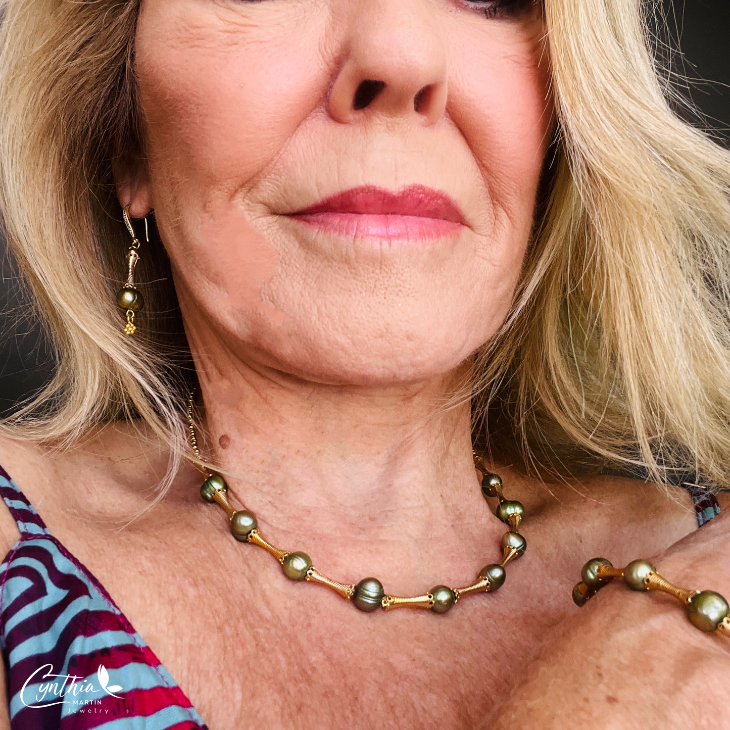 Stylish bracelet with iridescent green pearls and gold tube spacers, perfect for casual or corporate attire.