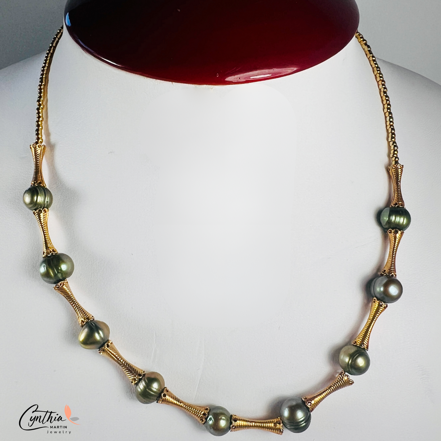 Elegant choker featuring iridescent green pearls and gold tube spacers, perfect for both casual and corporate attire.