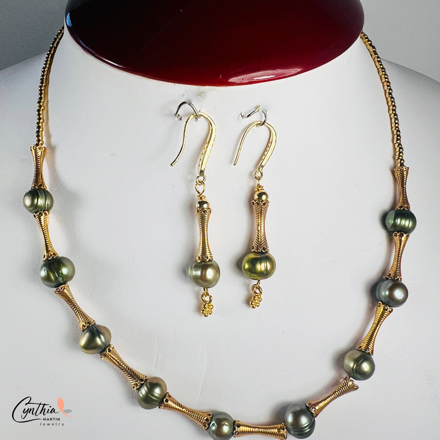 Elegant choker featuring iridescent green pearls and gold tube spacers, perfect for both casual and corporate attire.