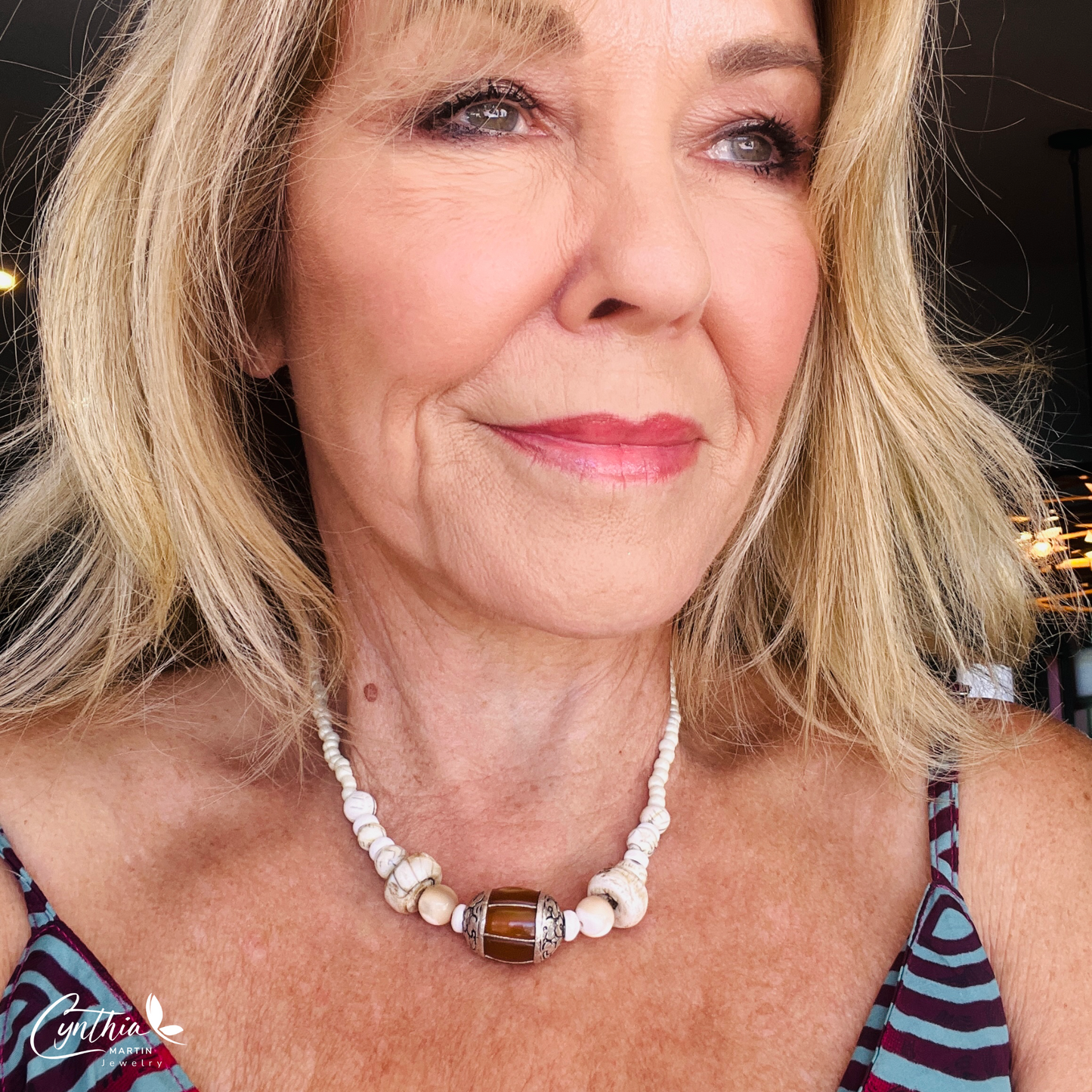 Necklace featuring an Indonesian silver and amber focal bead, accented with agate beads, natural stones, and glossy white beads, 15 inches with a 2-inch extender.