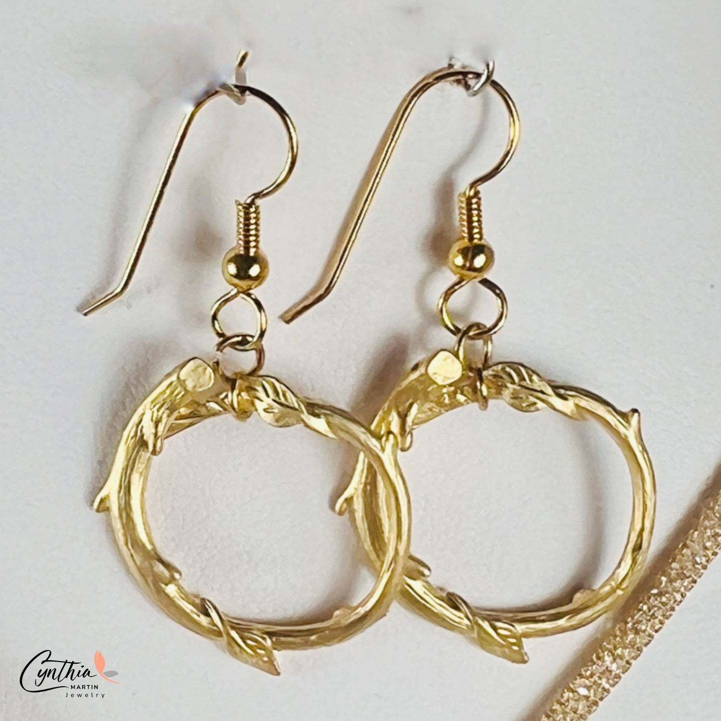 Gold round loop earrings with a matte finish, offering a dainty and timeless look.