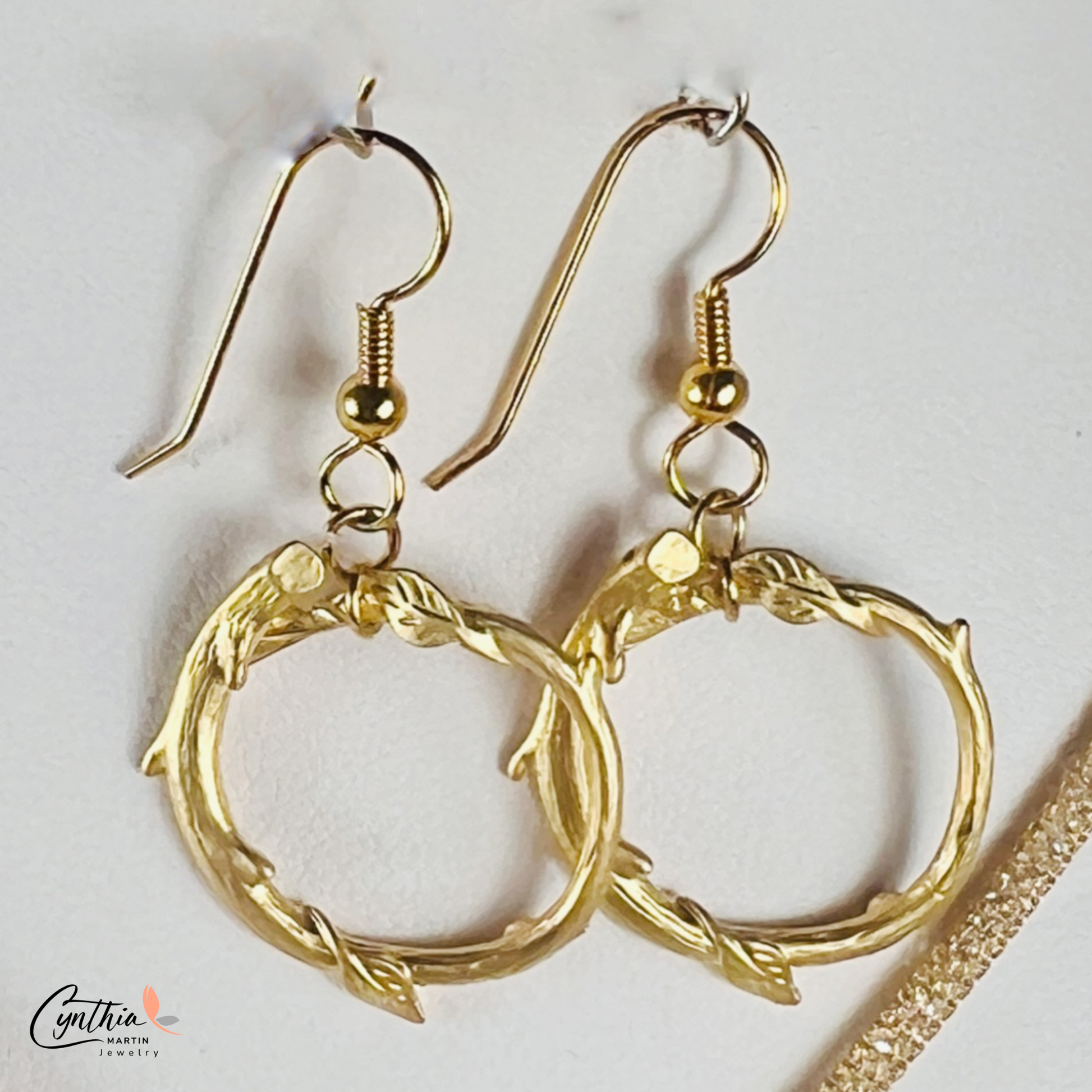 Gold round loop earrings with a matte finish, offering a dainty and timeless look.