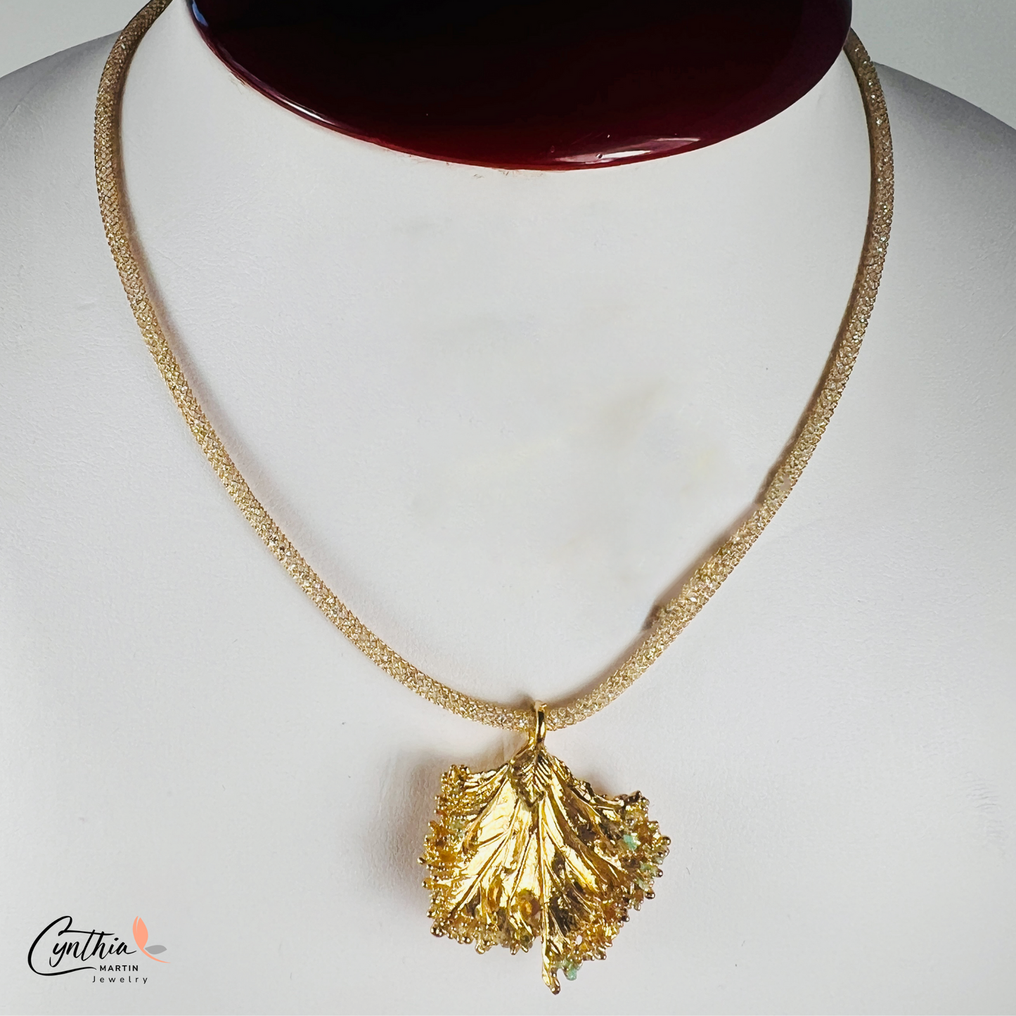 Gold pendant with a ruffled texture attached to an Italian mesh necklace, featuring embedded cubic zirconia.