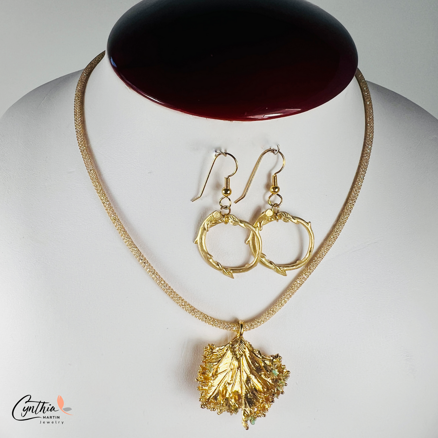 Gold pendant with a ruffled texture attached to an Italian mesh necklace, featuring embedded cubic zirconia.