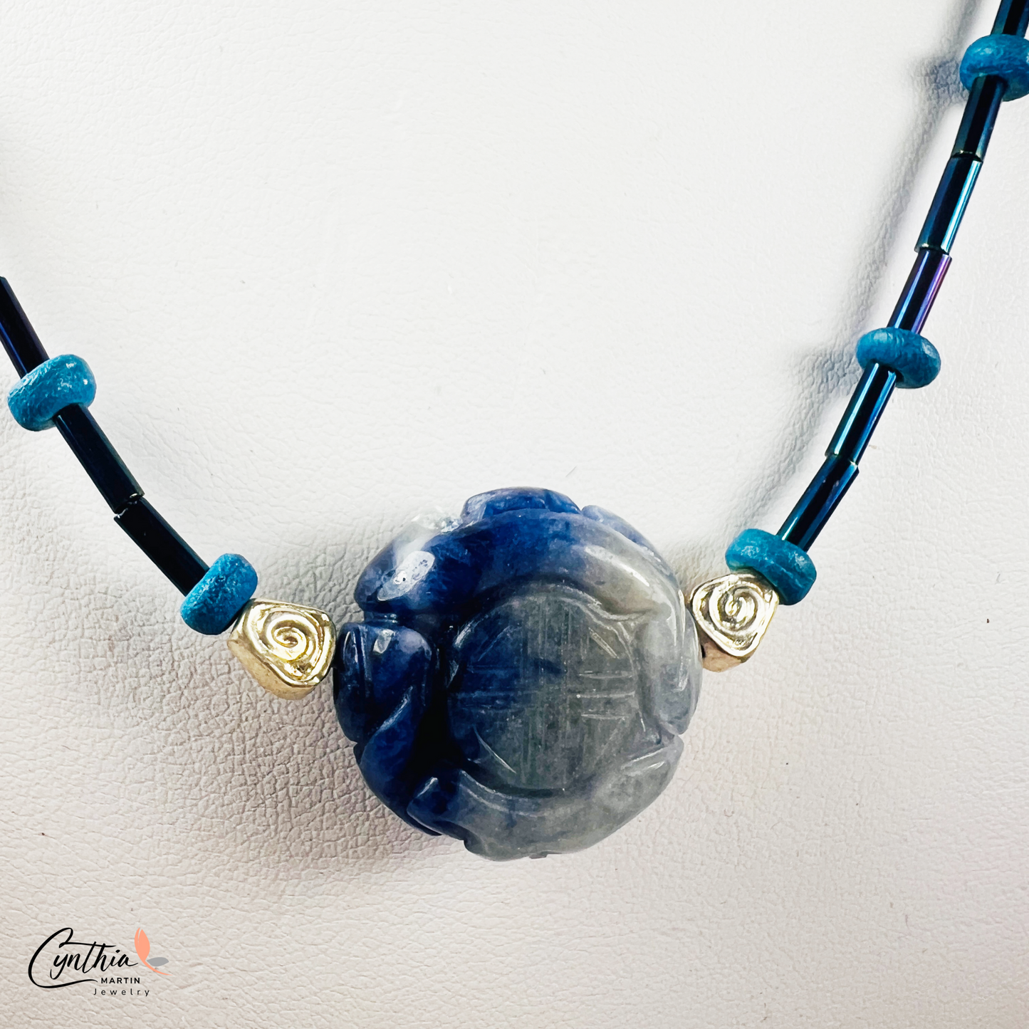 Dainty necklace featuring an Indonesian etched milky dark blue stone focal bead with cobalt blue and ultramarine tube beads, 15 inches with 2-inch extender.