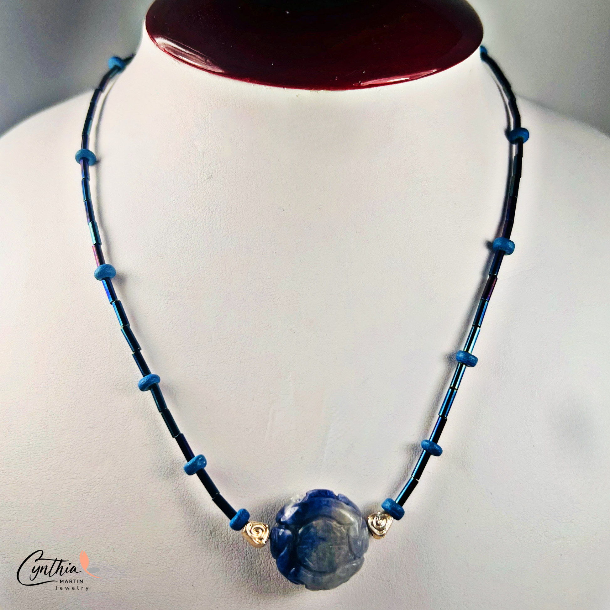 Dainty necklace featuring an Indonesian etched milky dark blue stone focal bead with cobalt blue and ultramarine tube beads, 15 inches with 2-inch extender.
