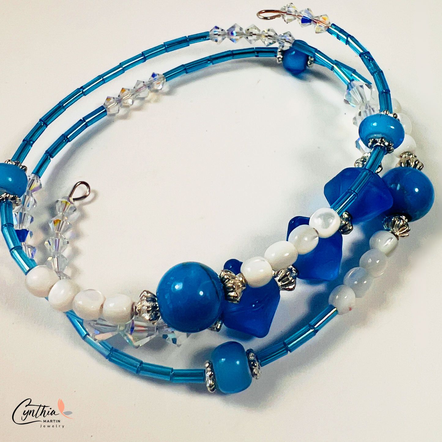 Bracelet featuring blue and iridescent white mother-of-pearl beads with sterling silver accents, delicately hugging 6mm beads.