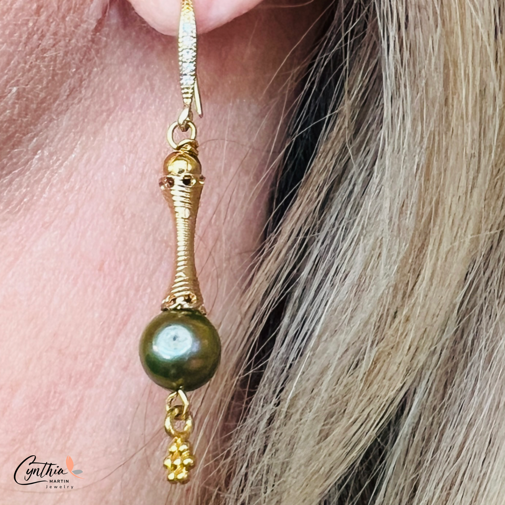 Elegant earrings featuring iridescent green pearls and gold tube spacers, perfect for casual or corporate wear.