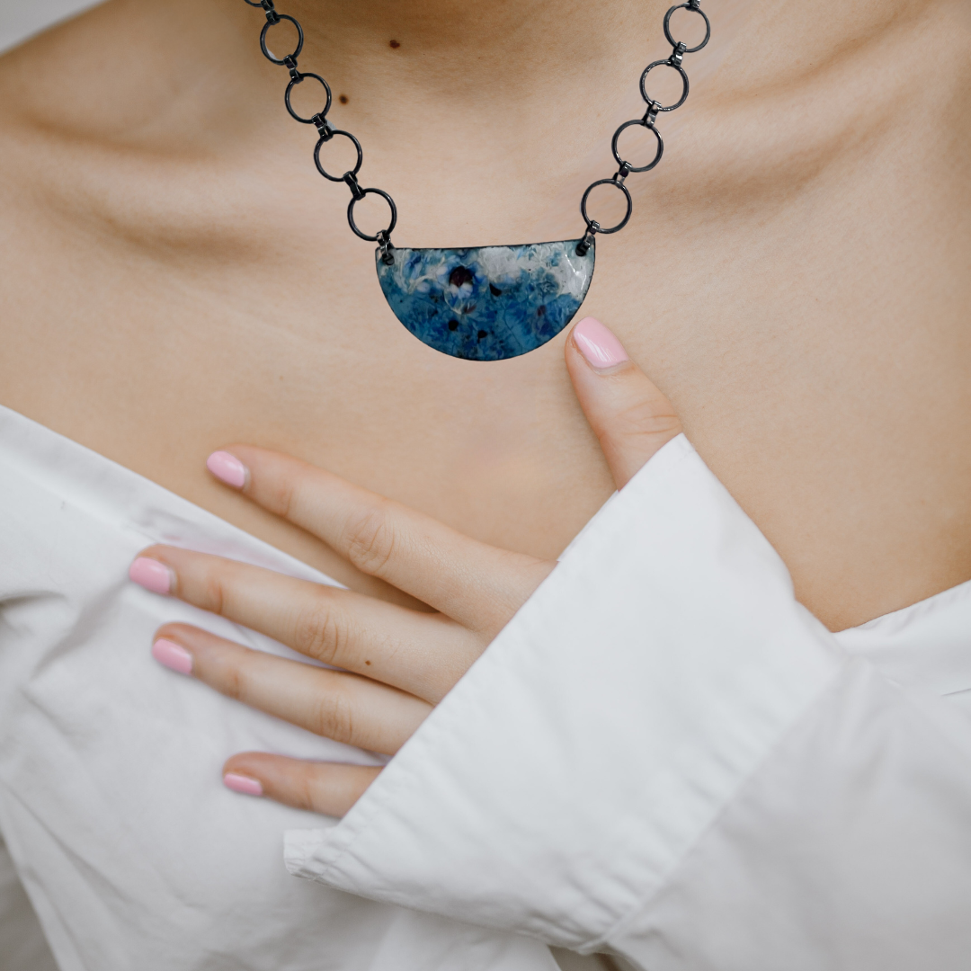 Antique chain necklace with blue enamel pendant depicting crashing waves, capturing the serene beauty of the beach with vintage charm.