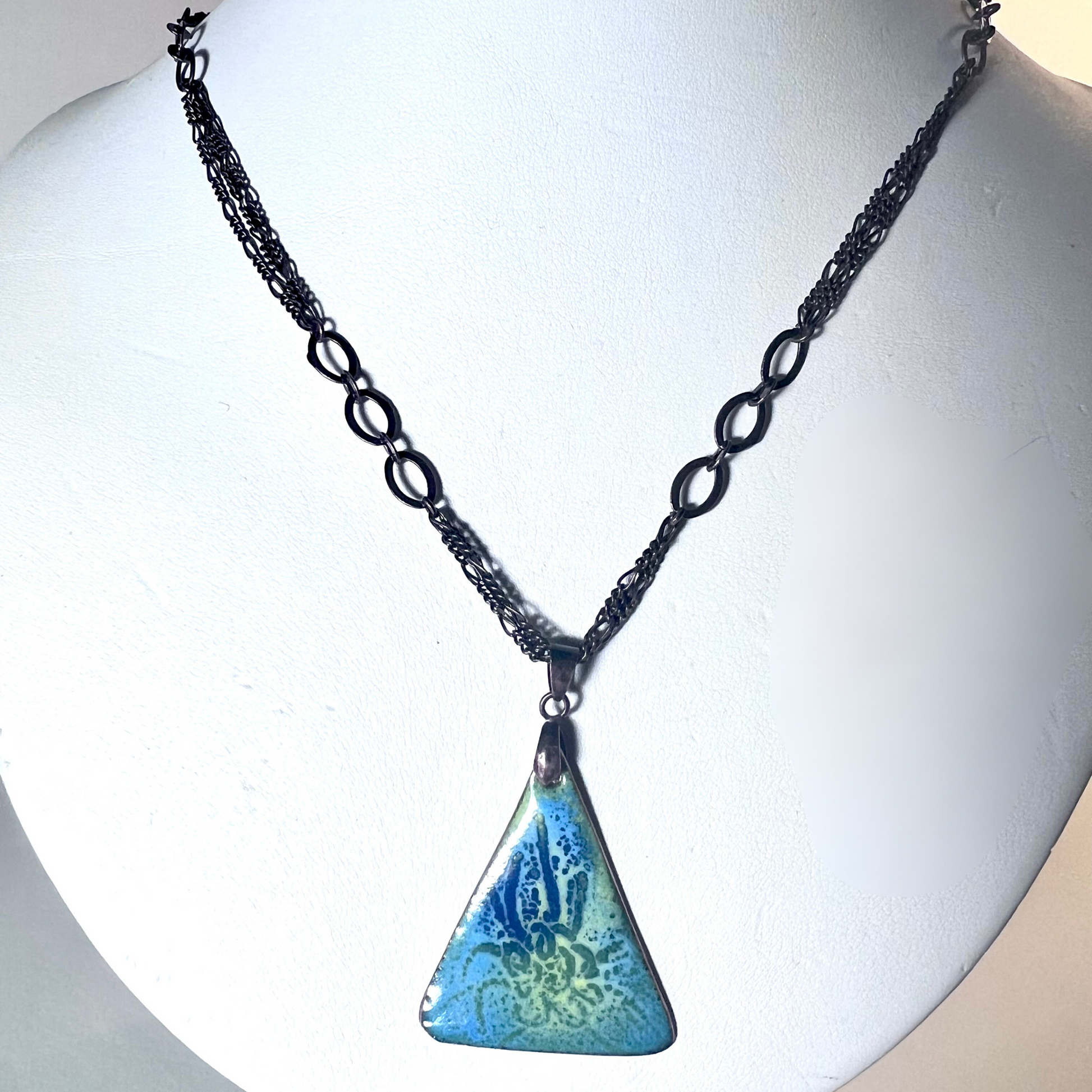 Striking pendant featuring an underwater scene crafted with six layers of multi-colored enamel using the sgraffito technique, showcasing vibrant marine life and aquatic elements, suspended from a dynamic tri-link copper chain.