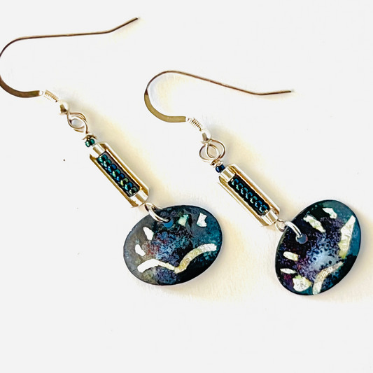 Black torch-fired enamel earrings with fine silver foil stars and seagulls, hanging on sterling silver ear wires with added beads for movement.