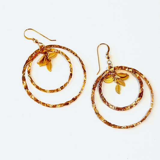 Dynamic dual-ringed hammered chandelier loop earrings with a cluster of tiny leaves in gold vermeil.