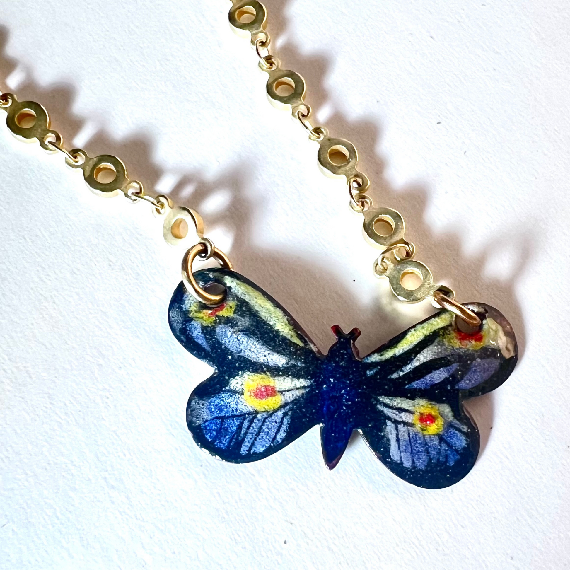 Gold small link chain with hand-painted enamel monarch butterfly pendant, blending luxury with the intricate beauty of nature.