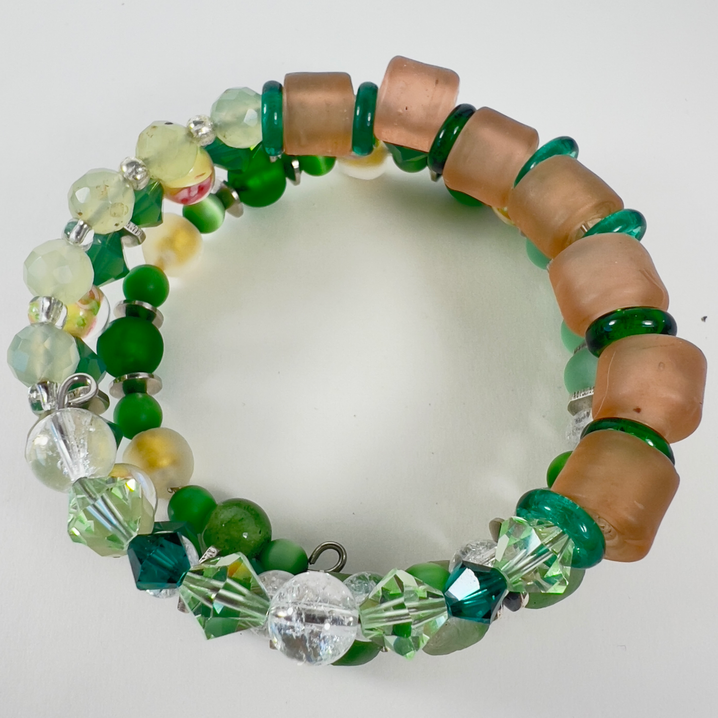 Multi-wrap bracelet featuring peach and green beads, sterling silver spacers, green cat-eye 4mm beads, sparkling transparent crystals, and 4mm beads with pink flower designs.