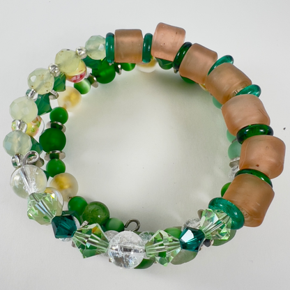 Multi-wrap bracelet featuring peach and green beads, sterling silver spacers, green cat-eye 4mm beads, sparkling transparent crystals, and 4mm beads with pink flower designs.