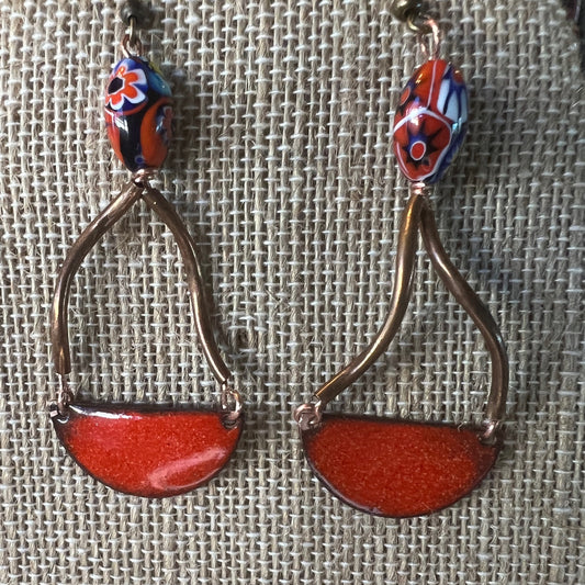 Striking earrings with red enamel half circles, dangling from copper tubes, adorned with African tribal beads. A unique, exotic statement piece, combining elegance, cultural accents, and textural interest. Ideal for any occasion.