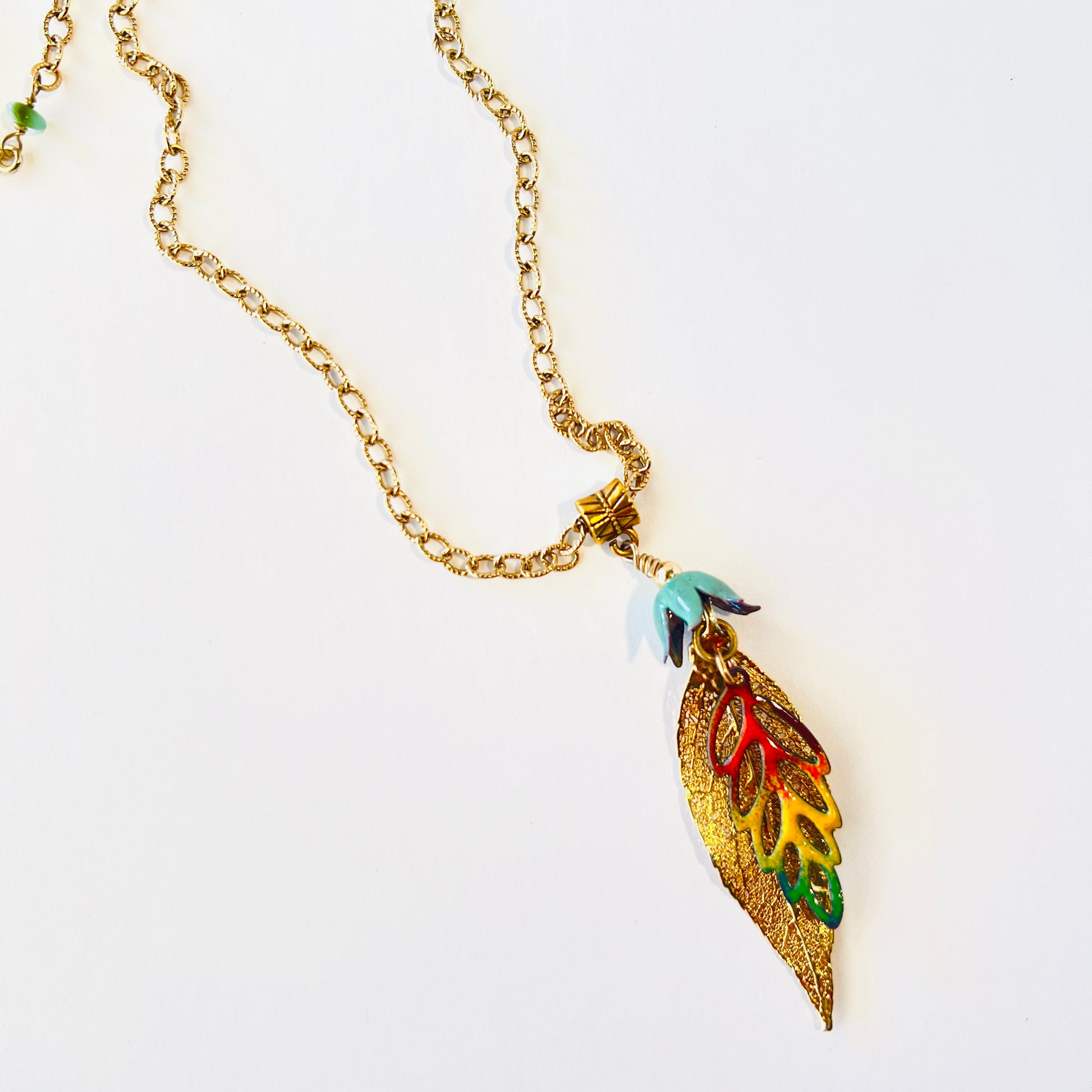 Dainty gold chained necklace adorned with a pair of leaves