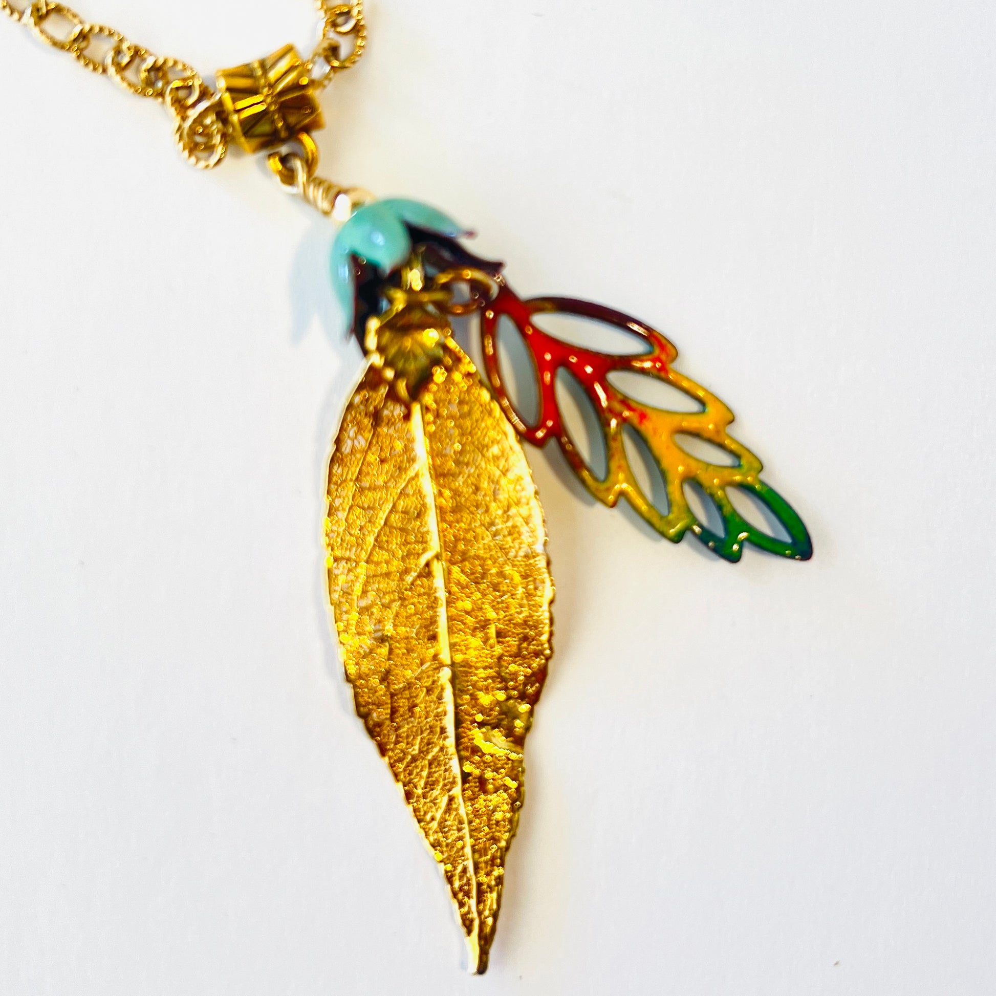 Dainty gold chained necklace adorned with a pair of leaves