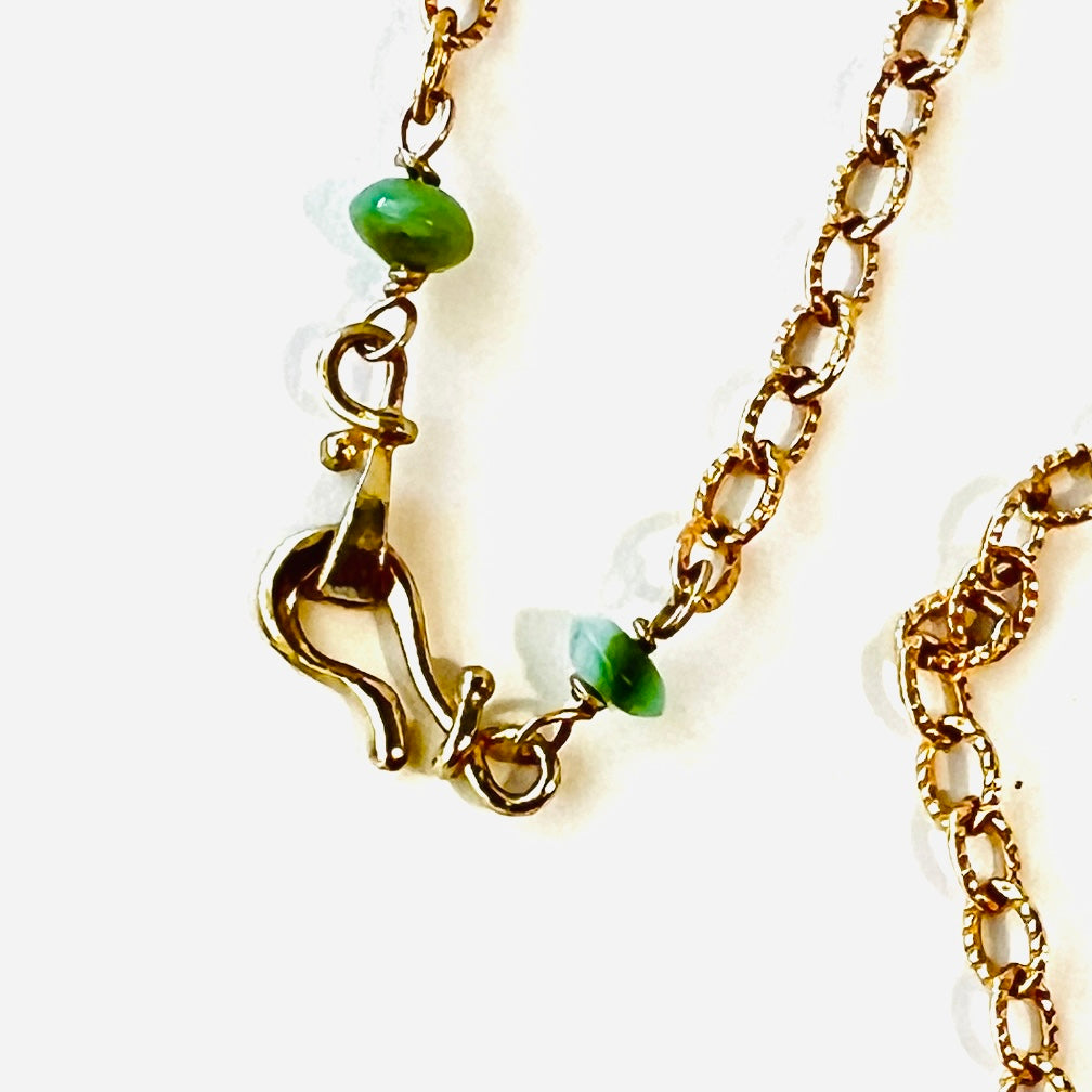 Dainty gold chained necklace adorned with a pair of leaves