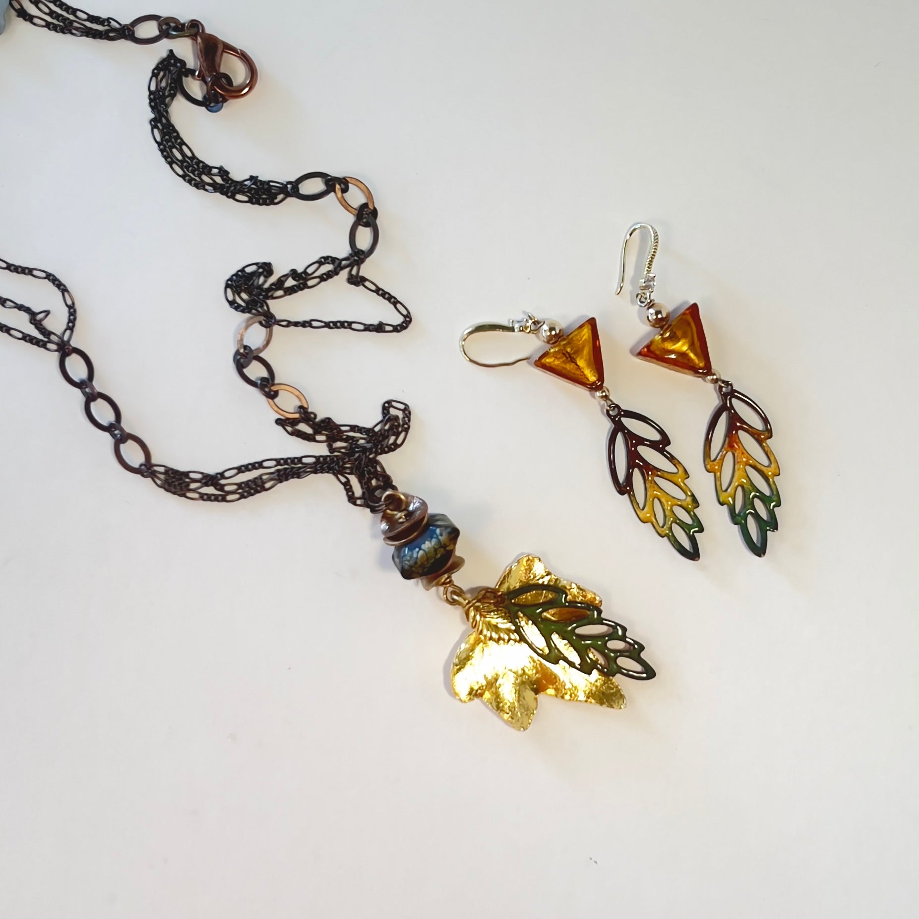 Brass multi-chain necklace with gold Aspen leaf and enameled tri-colored leaf, finished with handmade bead by Tucson Bead Artist Tennessa Mclean