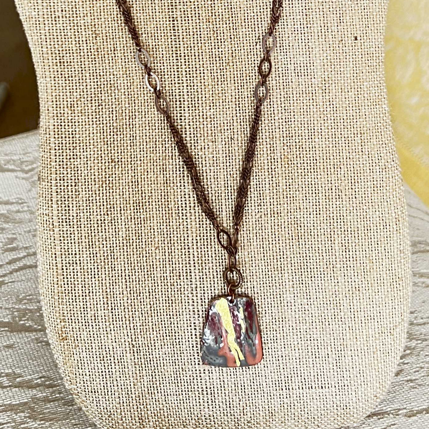 Multi-strand necklace with gold foil accents, copper pendant, and dark bronze chain, featuring an easily adjustable design and removable magnetic clasp.