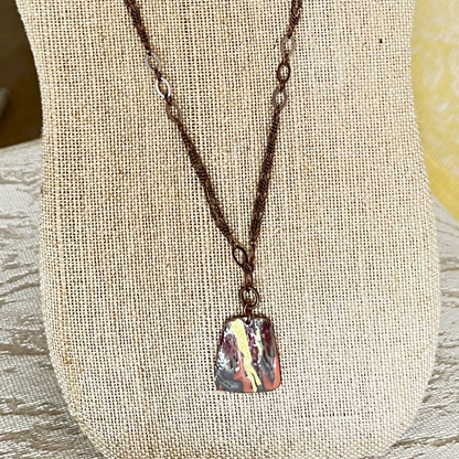 Multi-strand necklace with gold foil accents, copper pendant, and dark bronze chain, featuring an easily adjustable design and removable magnetic clasp.