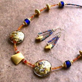 Exquisite necklace featuring Murano Venetian lentil beads and vibrant orange and gold seed beads.