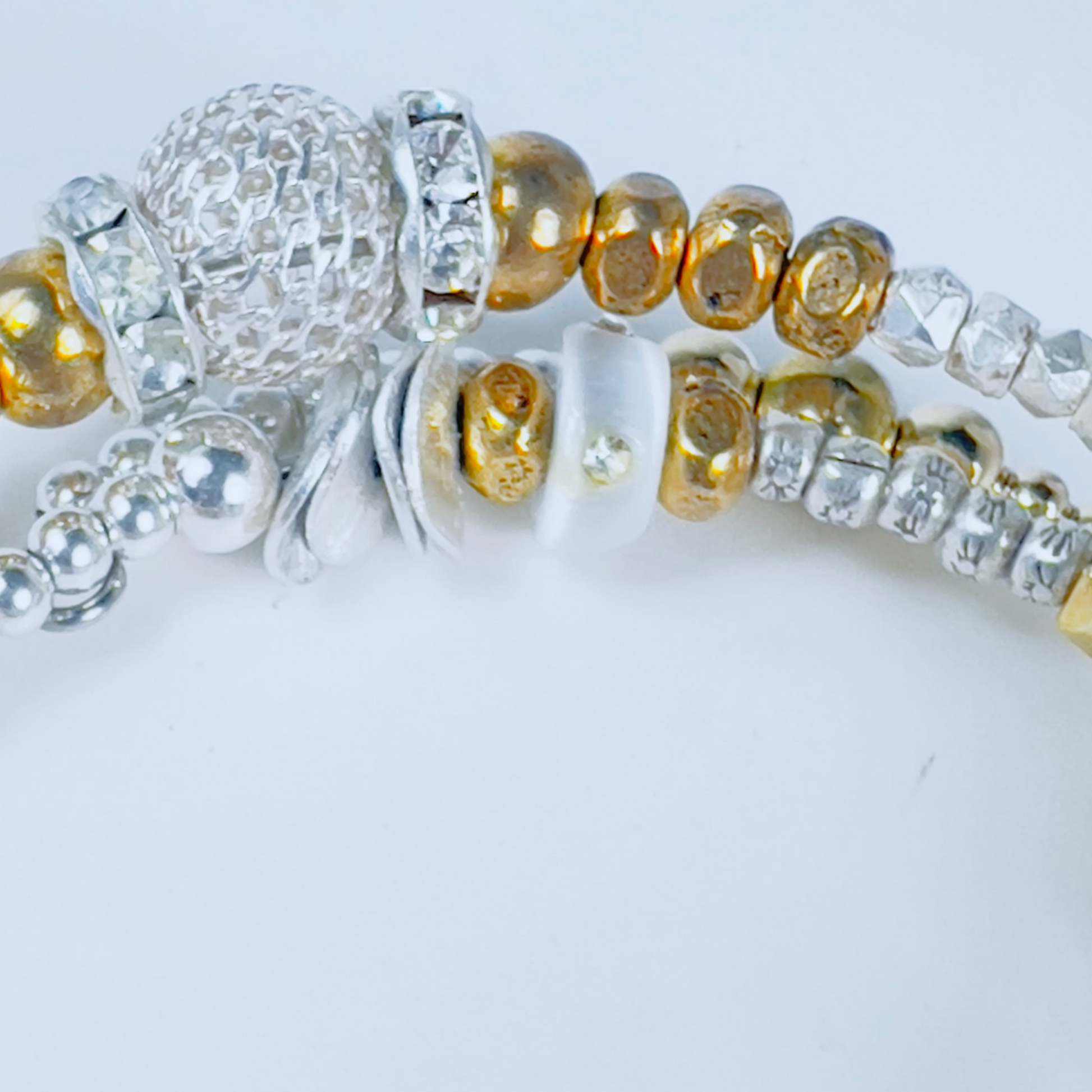 Elegant bracelet with pearls, crystal rondelles, spheres, pave barrel beads, and silver and gold beads in multiple sizes, ideal for stacking and special occasions.