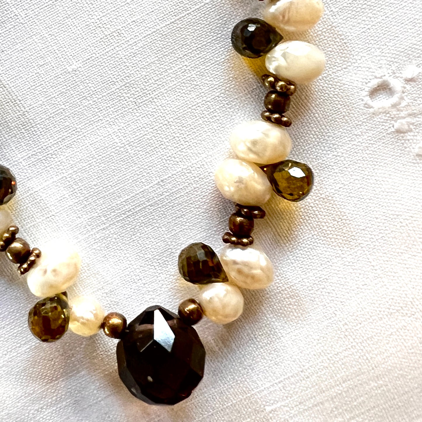 Elegant necklace featuring pearls and topaz crystals arranged along a 16-inch copper chain.