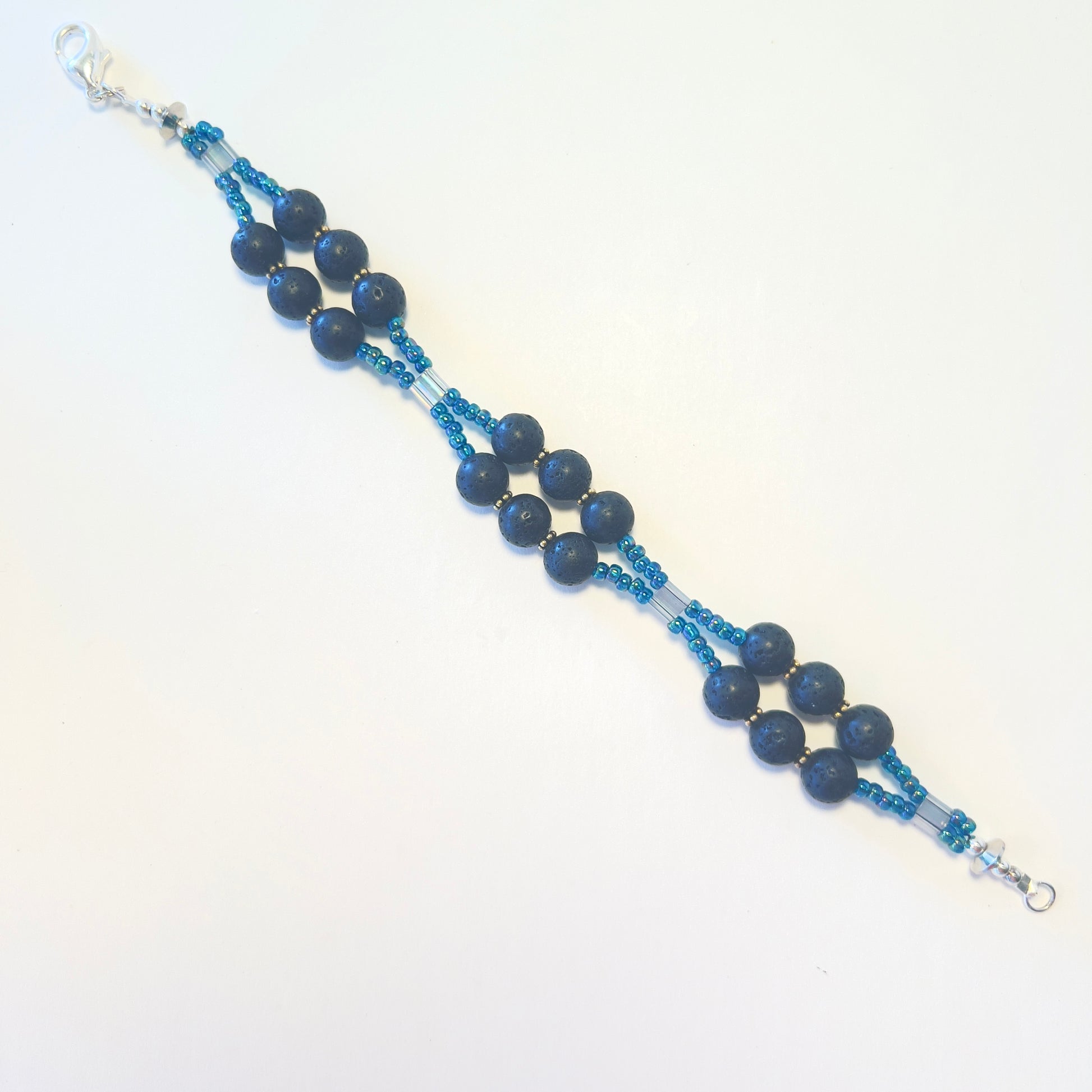 Double-strand gemstone bracelet featuring black lava rock beads and vivid blue seed beads, secured with a sleek lobster clasp