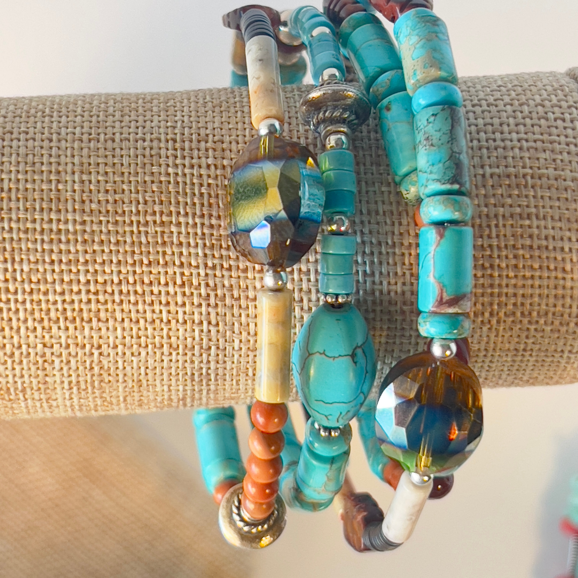 This is a naturally elegant wrap bracelet with hand-polished brilliant turquoise tubes and rondelle spacers. Designed with beautiful turquoise colors, coral, and brown and cream high-polished agate and glass. Silver metal, one size fits all.