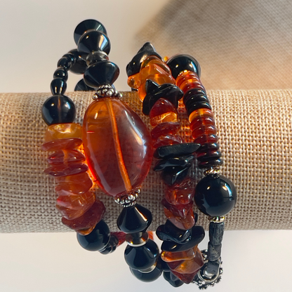 Stunning wrap bracelet with an amazing Baltic Sea amber nugget focal bead, multiple large chips of amber, black and amber rondelle spacers, and black onyx beads in round and diamond shapes. Silver metal, one size fits all.