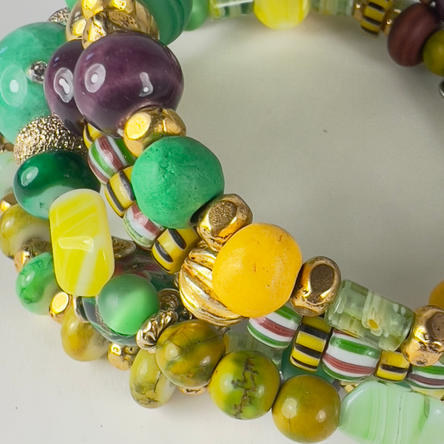 Festive green, yellow, and gold 5-layer bracelet with gold-filled spacers, millefiori green tubes, crystal sphere beads, and agate brown beads, perfect for Mardi Gras celebrations.