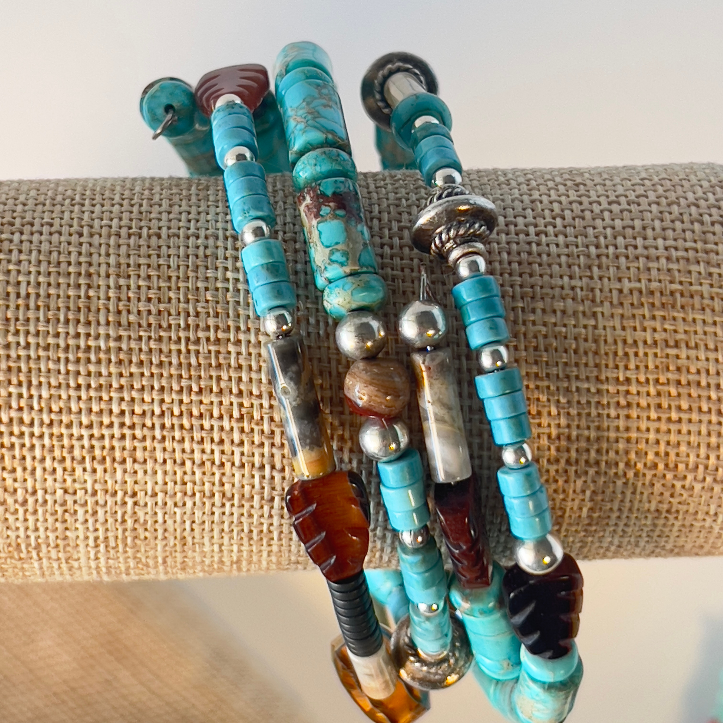 This is a naturally elegant wrap bracelet with hand-polished brilliant turquoise tubes and rondelle spacers. Designed with beautiful turquoise colors, coral, and brown and cream high-polished agate and glass. Silver metal, one size fits all.