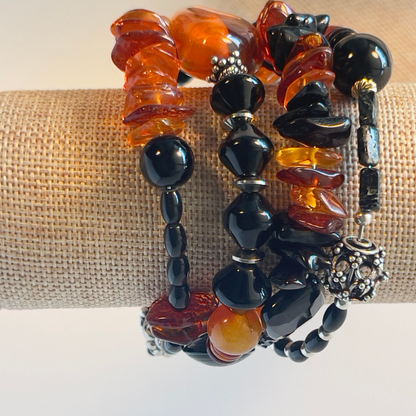 Stunning wrap bracelet with an amazing Baltic Sea amber nugget focal bead, multiple large chips of amber, black and amber rondelle spacers, and black onyx beads in round and diamond shapes. Silver metal, one size fits all.