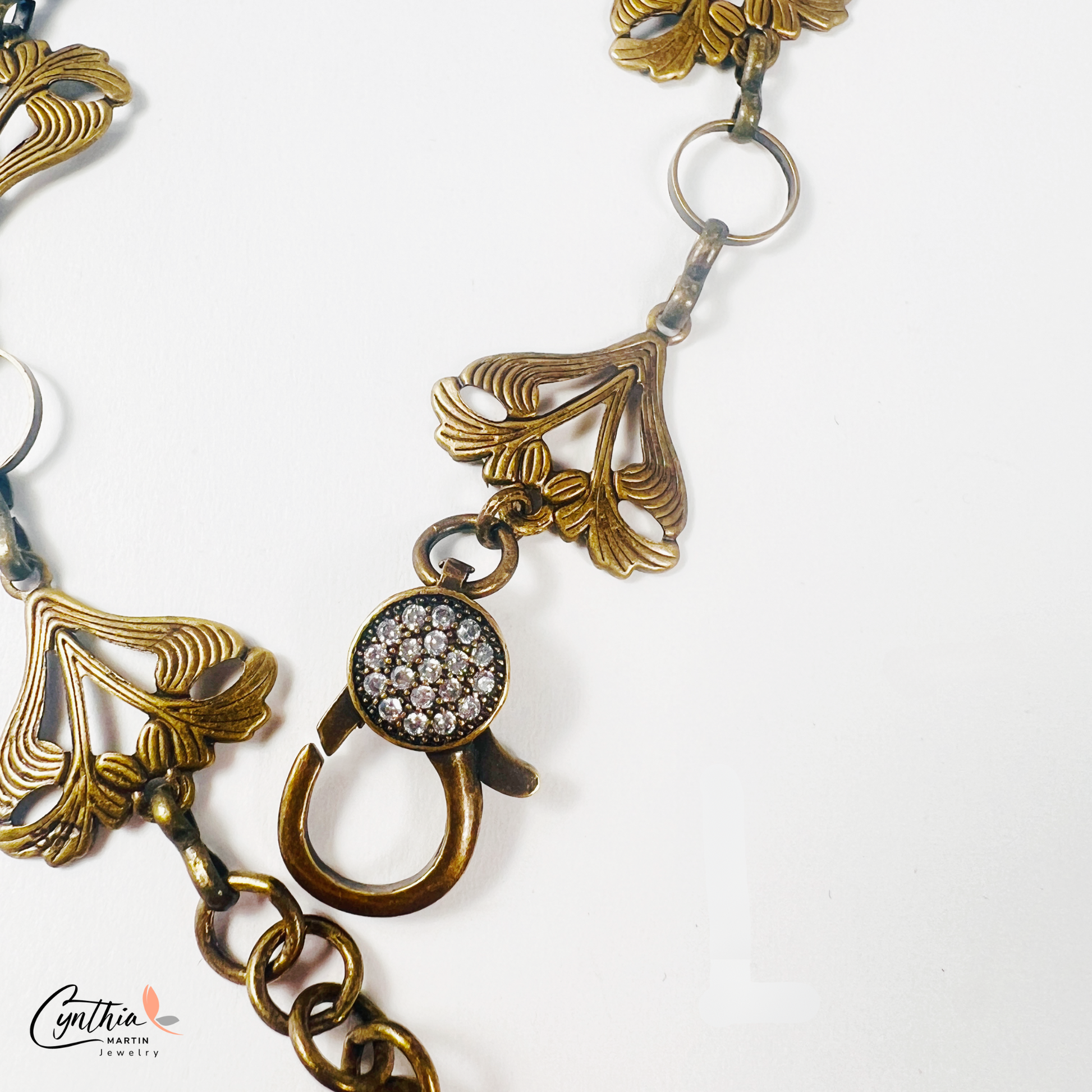 Art Nouveau-inspired jewelry set featuring delicate sun-kissed garden flowers, a bronze bonsai tree charm, and a sparkling pavé lobster clasp.
