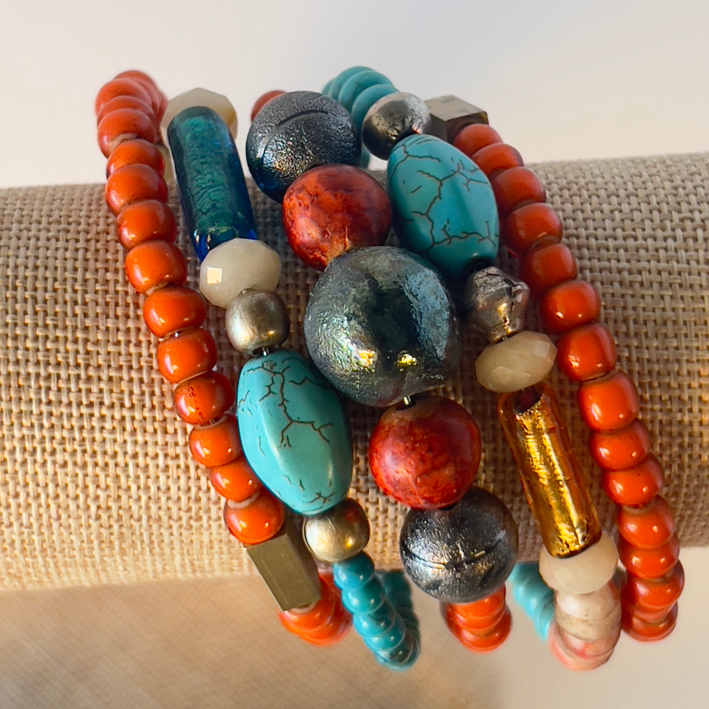 Celebrate the true Native American look with multi-orange coral and turquoise in various shapes, accented with brass and copper metals. Includes splashes of foiled Murano glass from Italy. Silver metal, one size fits all.