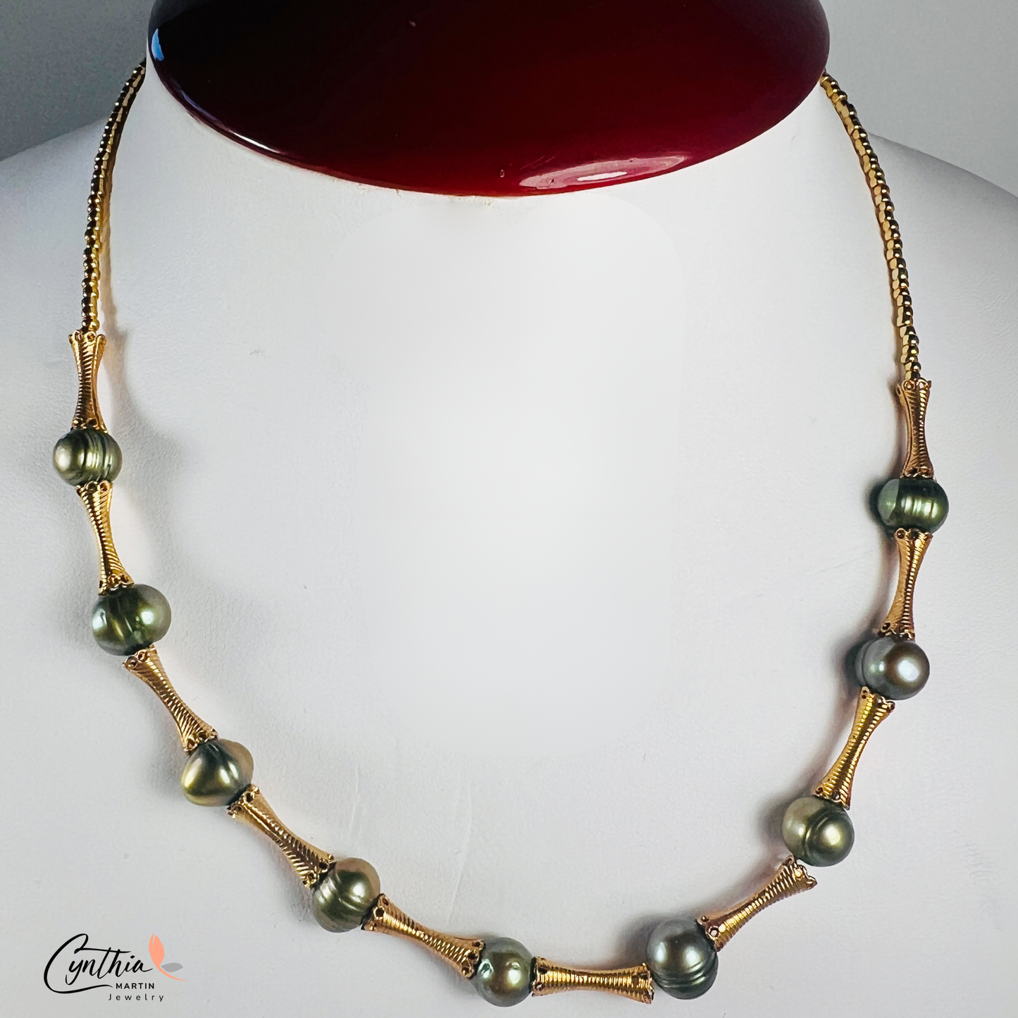 Elegant choker featuring iridescent green pearls and gold tube spacers, perfect for both casual and corporate attire.
