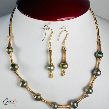 Elegant choker featuring iridescent green pearls and gold tube spacers, perfect for both casual and corporate attire.
