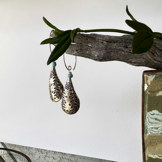 Earrings inspired by the nighttime flight of gulls, featuring sterling silver rectangle cages with dangling seed beads, crafted by Thailand Hill Tribe artisans in 99.9 pure silver.