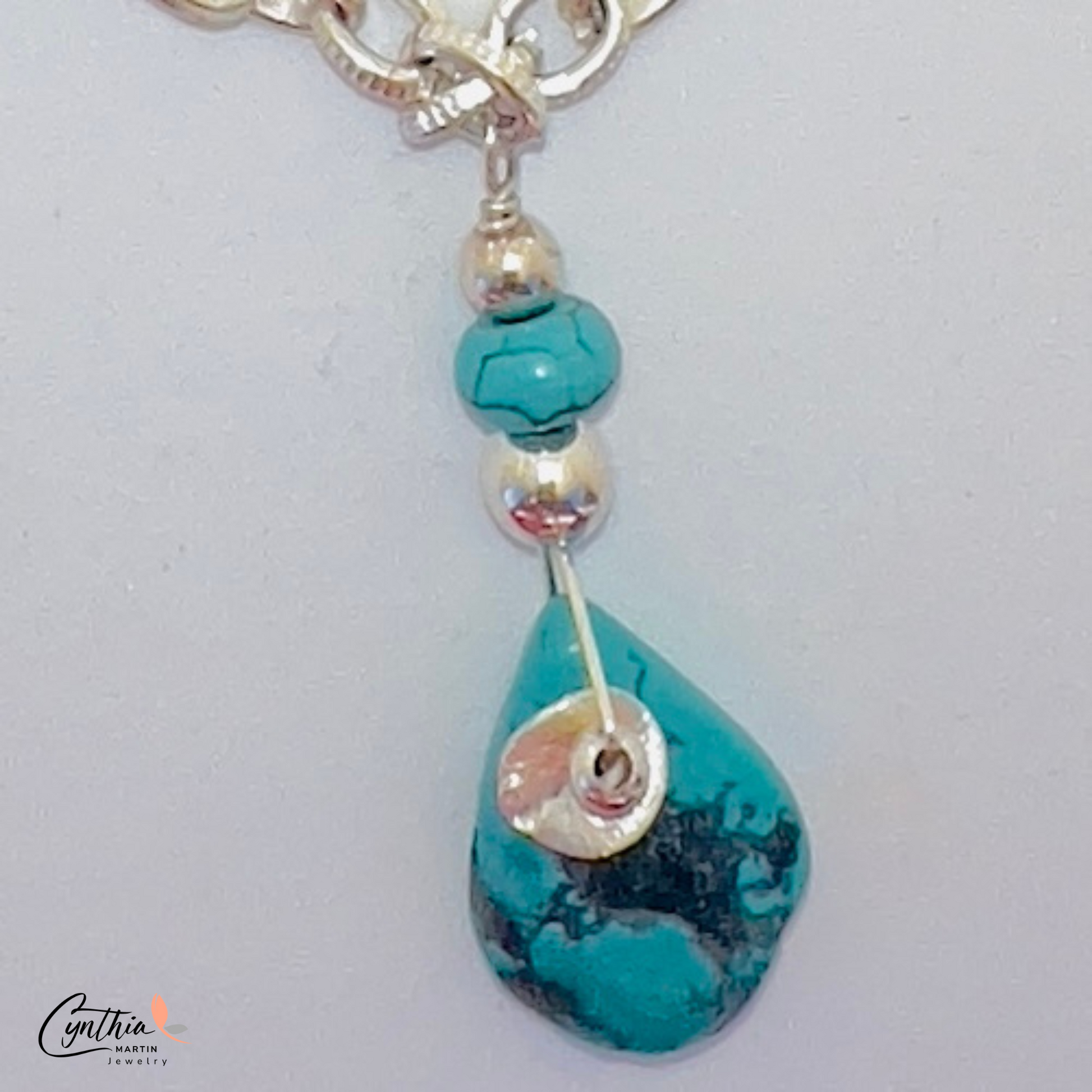 Authentic pear-shaped turquoise pendant dangling from a medium-link sterling silver chain.