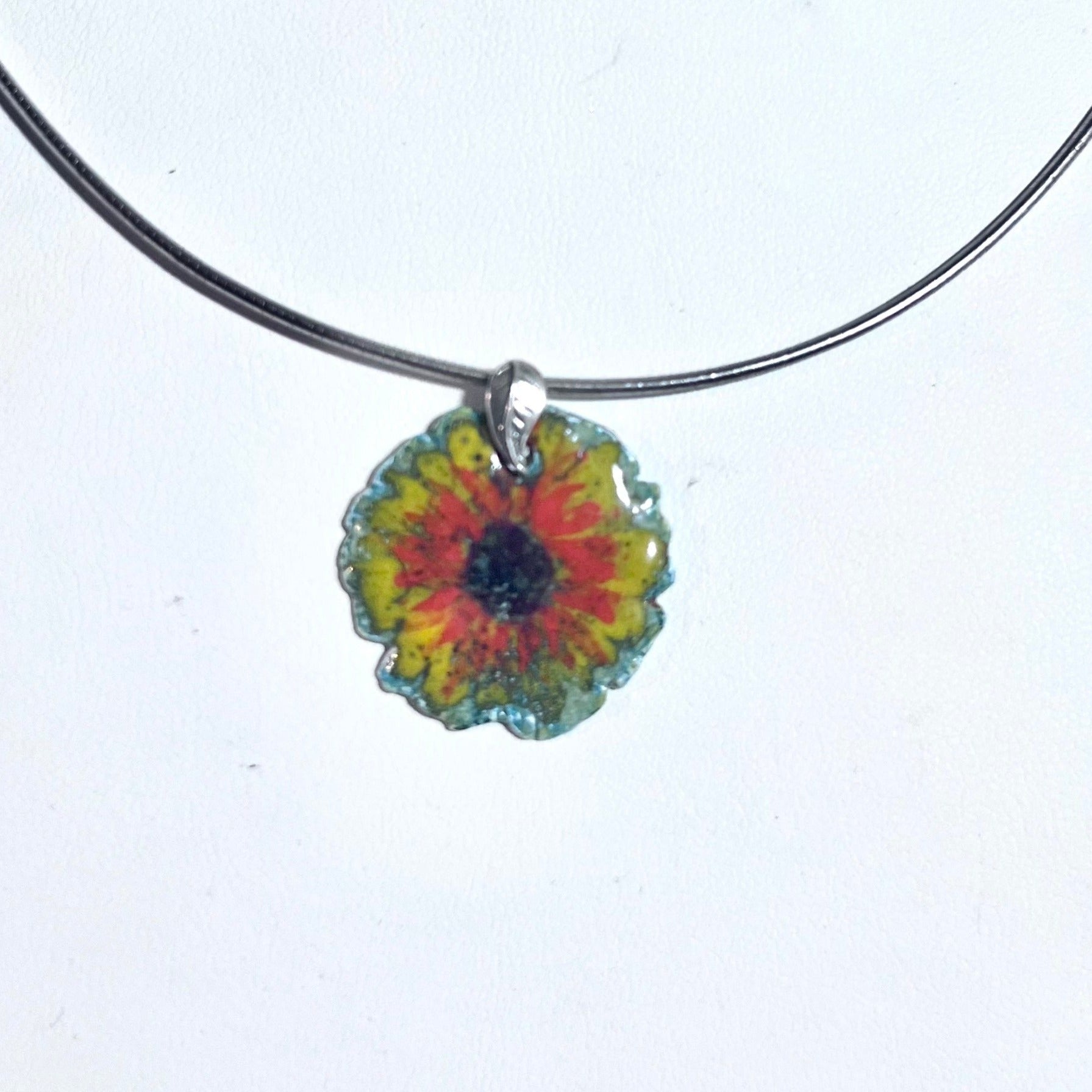 Fine silver sunflower pendant with blue enamel base, hand-painted yellow petals, and vibrant orange highlights on sterling silver omega chain.