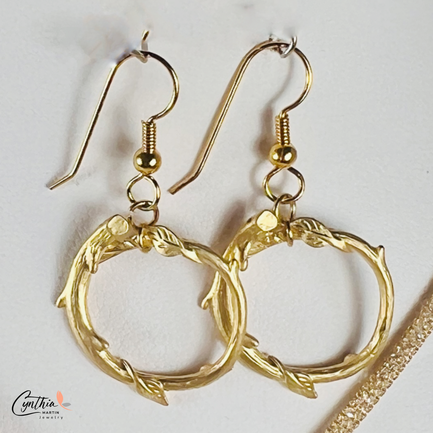 Gold round loop earrings with a matte finish, offering a dainty and timeless look.
