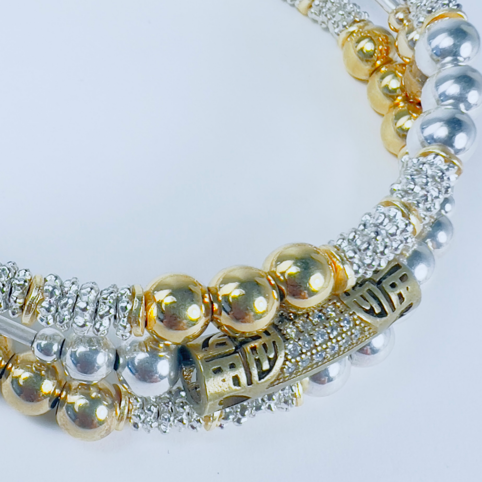 Three-wrap bracelet with Jakarta brass pave barrel, smaller gold and silver round beads, and tiny daisy spacers.