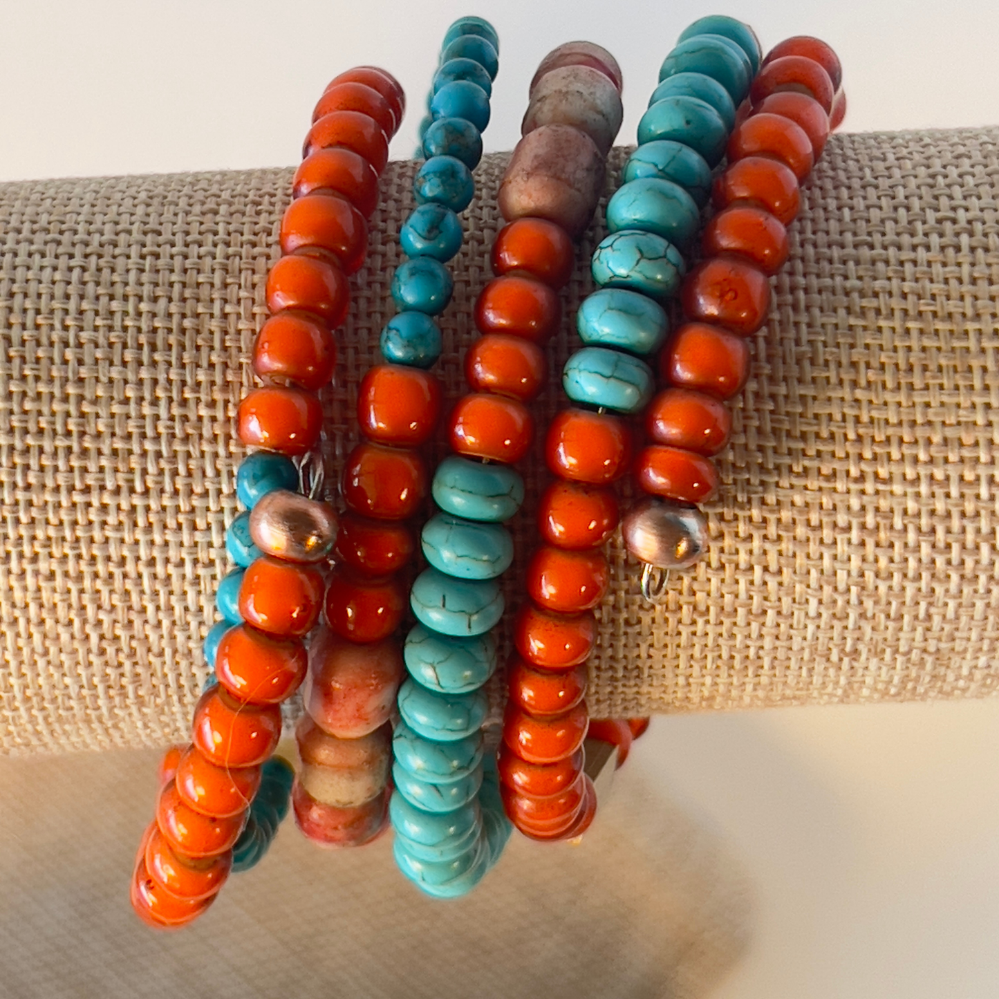 Celebrate the true Native American look with multi-orange coral and turquoise in various shapes, accented with brass and copper metals. Includes splashes of foiled Murano glass from Italy. Silver metal, one size fits all.